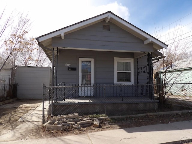 shotgun-style home featuring fence and a porch