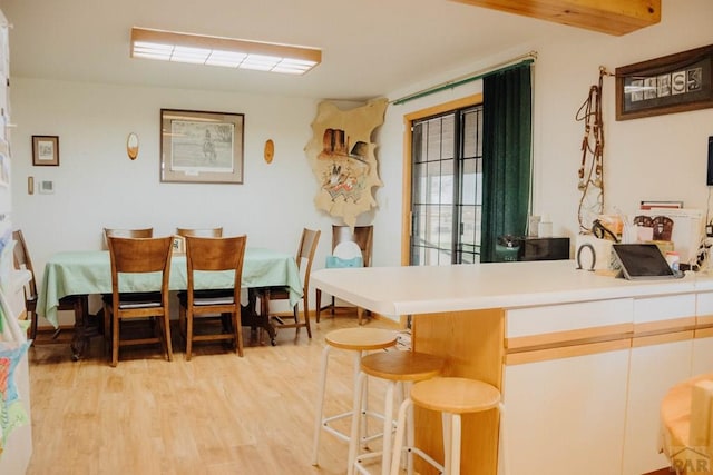 22661 Rd 24, La Junta, CO 81050 - kitchen with light countertops, a peninsula, a kitchen bar, and light wood finished floors