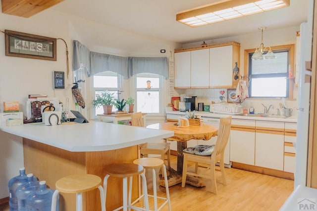 22661 Rd 24, La Junta, CO 81050 - kitchen with light wood-style floors, a peninsula, a wealth of natural light, and a breakfast bar