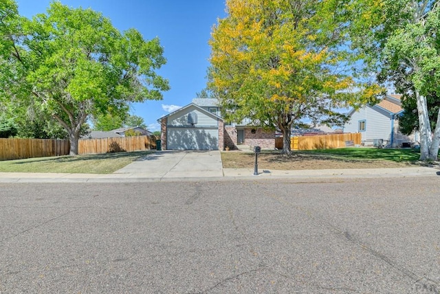 view of front of home featuring concrete driveway, an attached garage, and fence