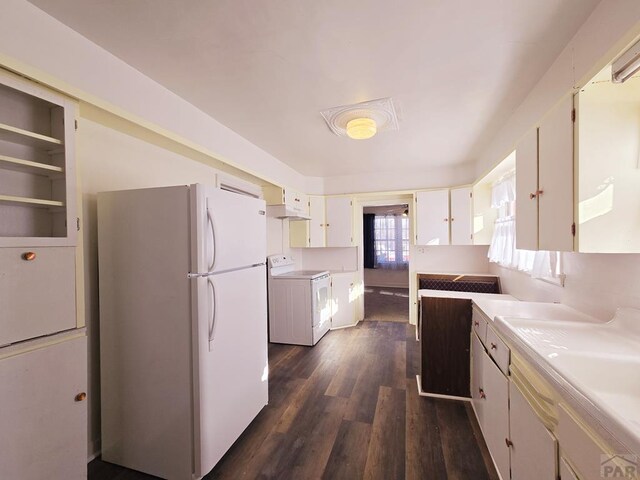 kitchen with white cabinets, stove, dark wood-type flooring, freestanding refrigerator, and light countertops