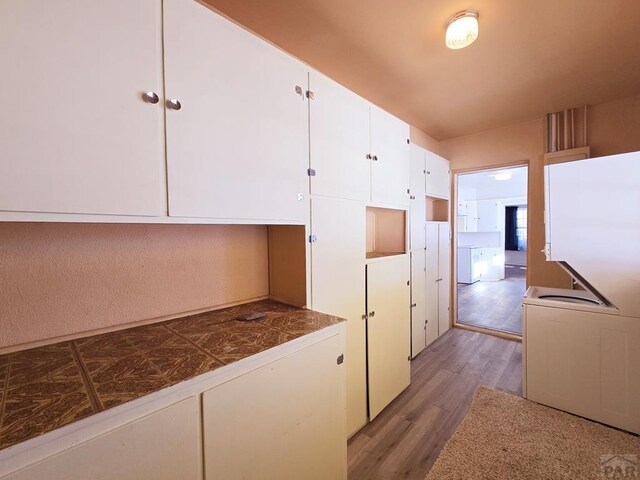 kitchen featuring white cabinetry, tile countertops, and light wood finished floors