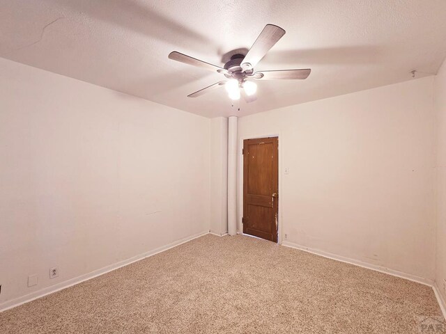 empty room with baseboards, a textured ceiling, a ceiling fan, and carpet flooring