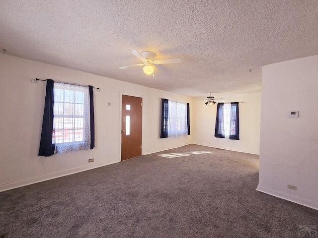 unfurnished room featuring dark carpet, a textured ceiling, and ceiling fan