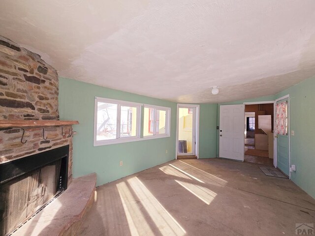 unfurnished living room featuring vaulted ceiling and a fireplace