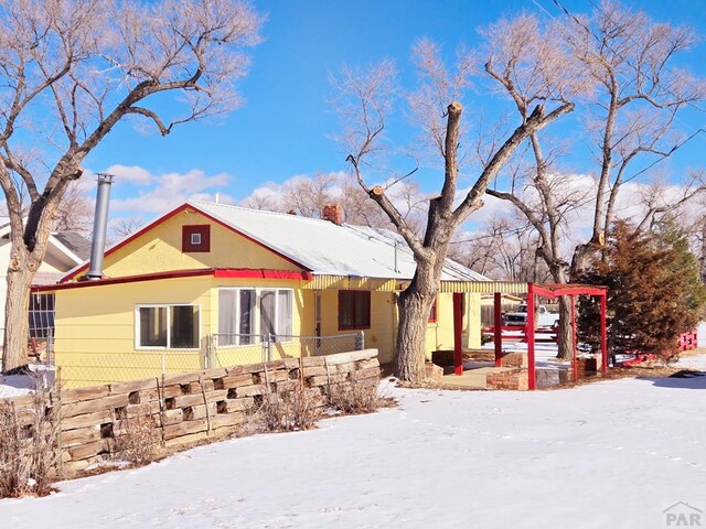 view of front of property with a chimney and fence