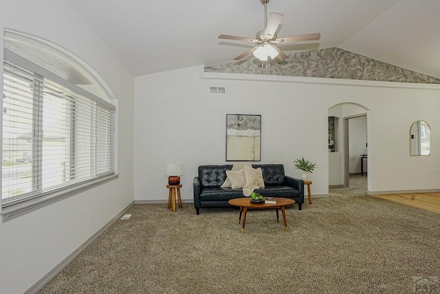 2221 Cliffmoor Ln, Pueblo, CO 81008 - living area with vaulted ceiling, arched walkways, ceiling fan, plenty of natural light, and light carpet