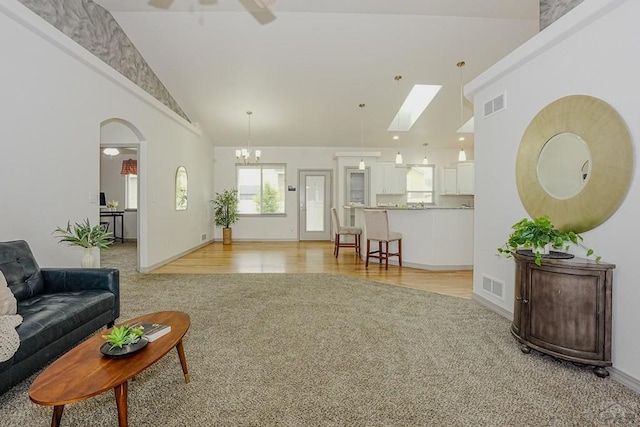 2221 Cliffmoor Ln, Pueblo, CO 81008 - living room with light colored carpet, high vaulted ceiling, ceiling fan, a skylight, and baseboards