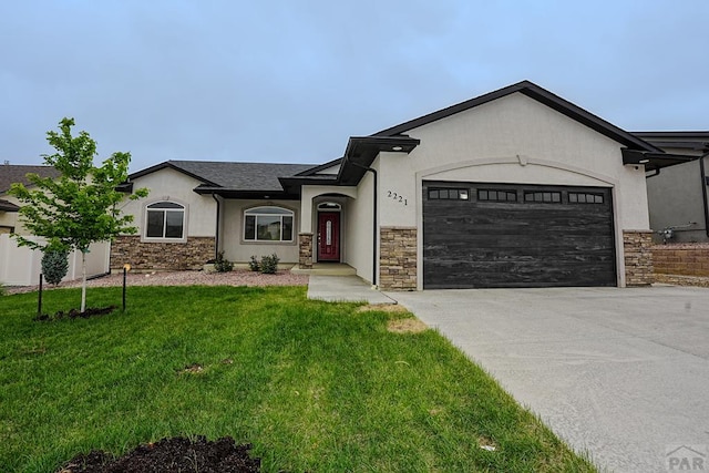 2221 Cliffmoor Ln, Pueblo, CO 81008 - ranch-style home featuring stucco siding, concrete driveway, an attached garage, stone siding, and a front yard