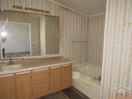 326 Katherine St, Avondale, CO 81022 - full bath featuring vanity, shower / bath combination with curtain, and wallpapered walls