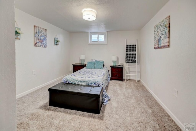 carpeted bedroom featuring a textured ceiling and baseboards