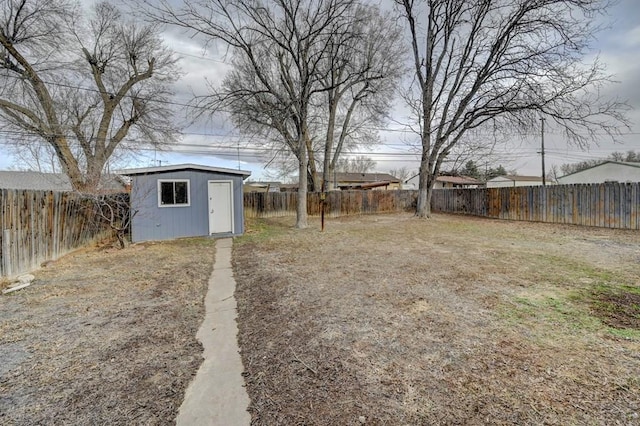 view of yard with a fenced backyard, a storage unit, and an outdoor structure