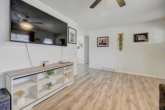 unfurnished living room featuring a ceiling fan, visible vents, baseboards, and wood finished floors