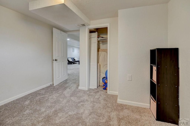 unfurnished bedroom featuring carpet, visible vents, and baseboards