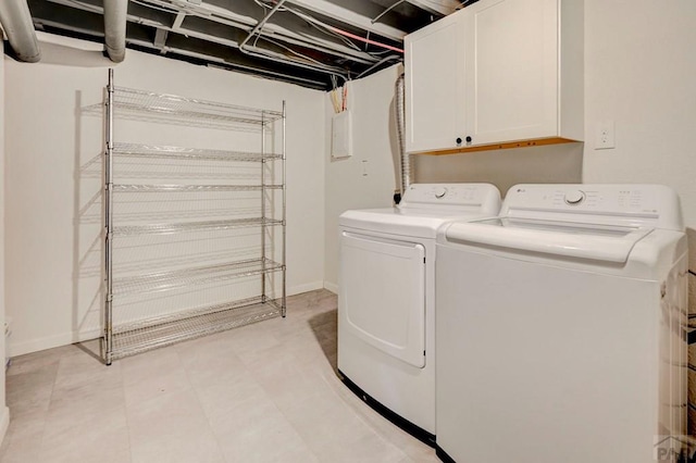 laundry room featuring cabinet space, baseboards, and washer and clothes dryer