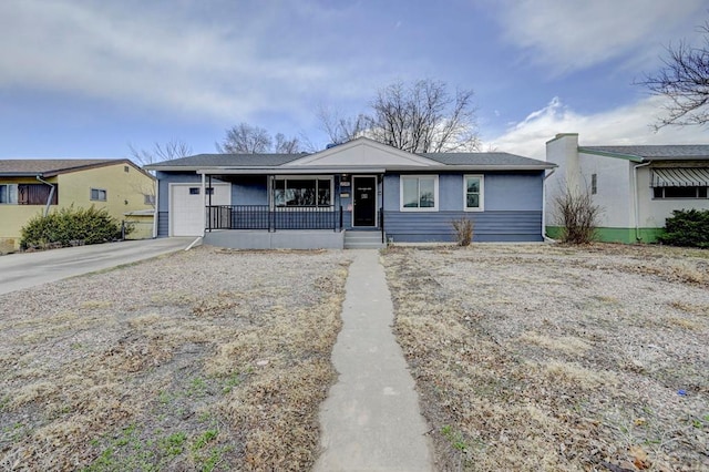 view of front of property with a garage, concrete driveway, and a porch