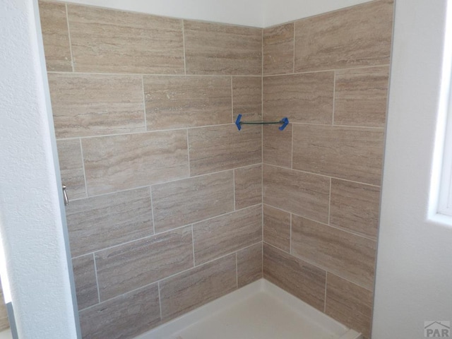 full bath with a tile shower