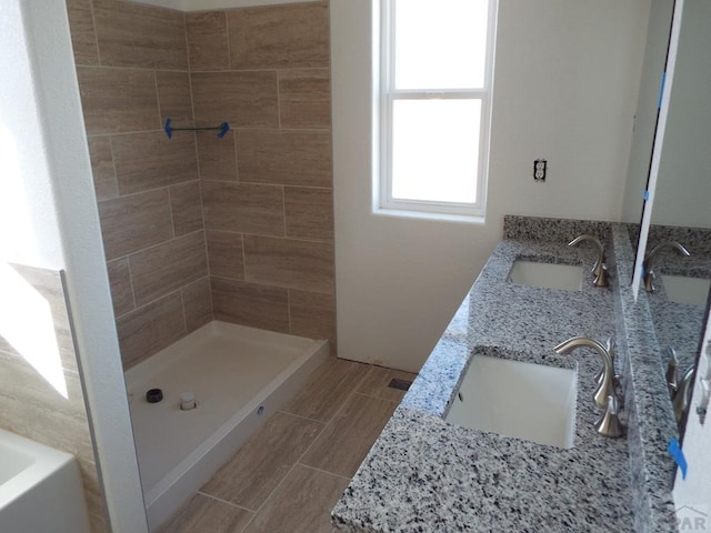 full bath with double vanity, wood tiled floor, a sink, and a shower stall