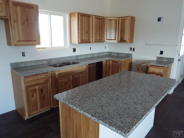 kitchen with a kitchen island, brown cabinets, and a sink