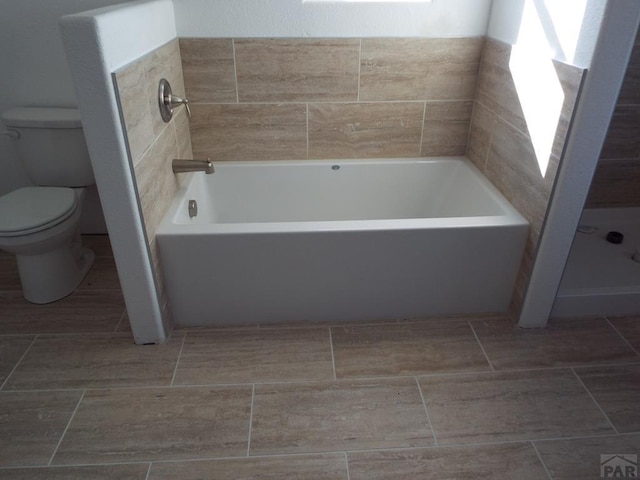 full bath with toilet and a garden tub