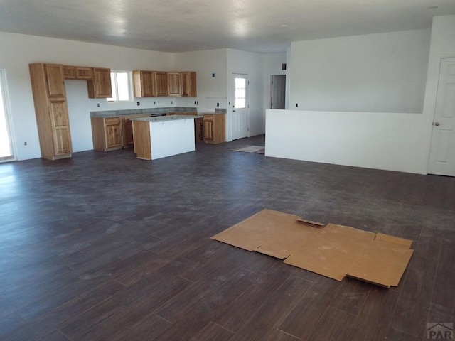 kitchen with open floor plan, light countertops, dark wood-type flooring, and a center island