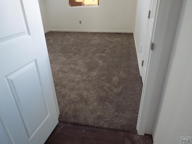 spare room with dark colored carpet