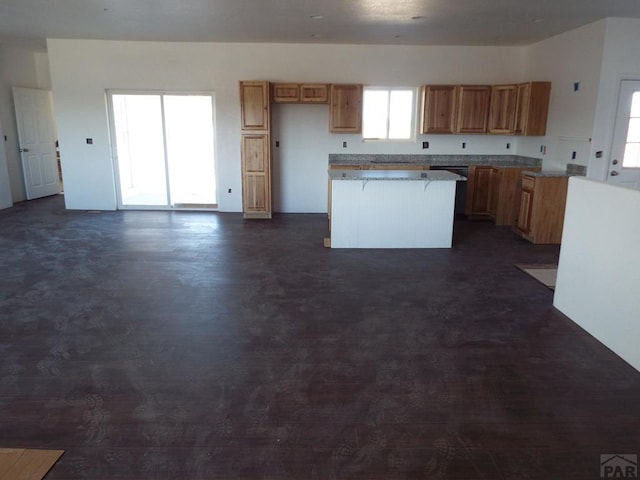 kitchen featuring light countertops, a kitchen island, and brown cabinets