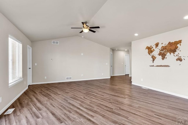 unfurnished living room with lofted ceiling, wood finished floors, visible vents, and baseboards