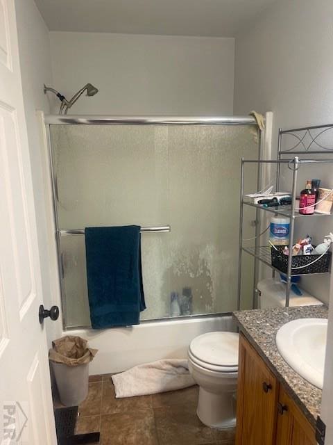 bathroom featuring enclosed tub / shower combo, toilet, and vanity