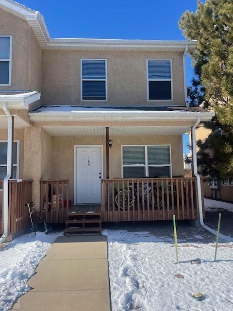 view of front of house featuring covered porch and stucco siding