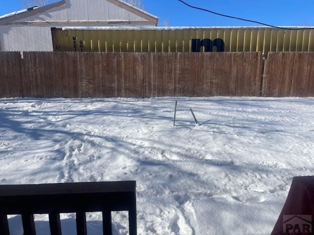 yard covered in snow featuring fence