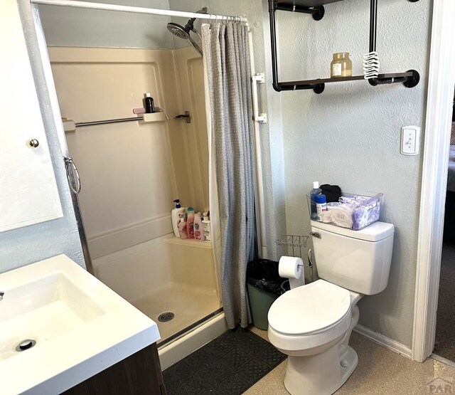 900 Van Buren St, Pueblo, CO 81004 - bathroom featuring a stall shower, toilet, vanity, a textured wall, and baseboards