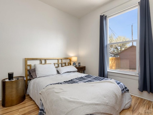 bedroom with baseboards and light wood finished floors