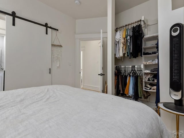 bedroom with a barn door and a closet