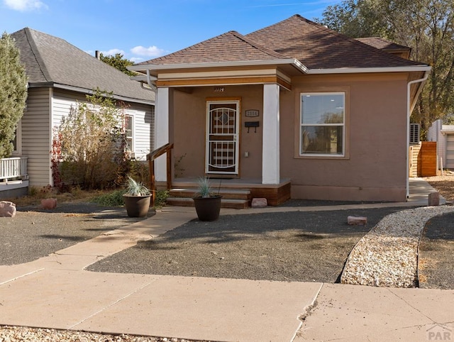 view of front of house featuring a shingled roof and stucco siding