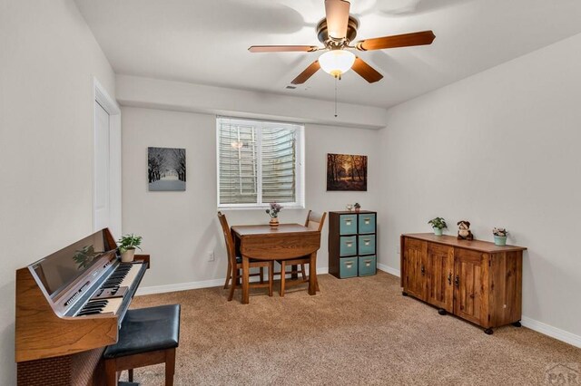 office featuring light carpet, ceiling fan, visible vents, and baseboards