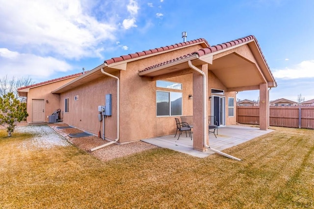 back of property with a tile roof, fence, a yard, a patio area, and stucco siding