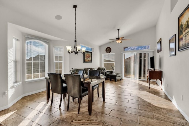 dining space featuring baseboards, vaulted ceiling, and ceiling fan with notable chandelier