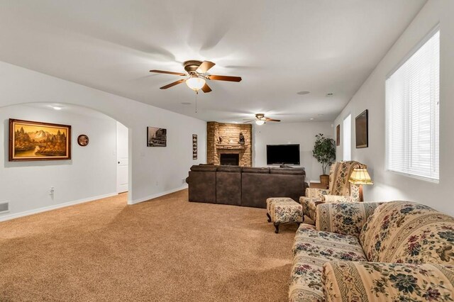 living area with visible vents, baseboards, light colored carpet, ceiling fan, and a fireplace