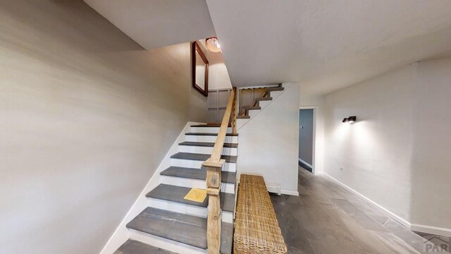 stairway with baseboards and wood finished floors