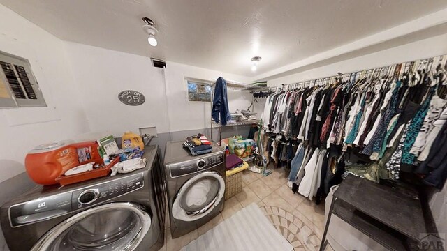 interior space with laundry area, independent washer and dryer, and light tile patterned floors