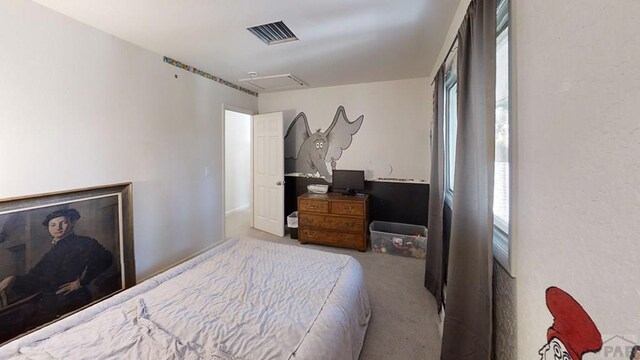 bedroom featuring light carpet, visible vents, and attic access