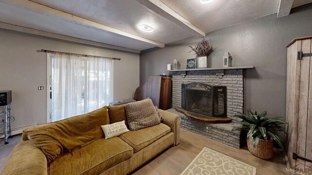 living area featuring light wood-type flooring, a fireplace, and beam ceiling