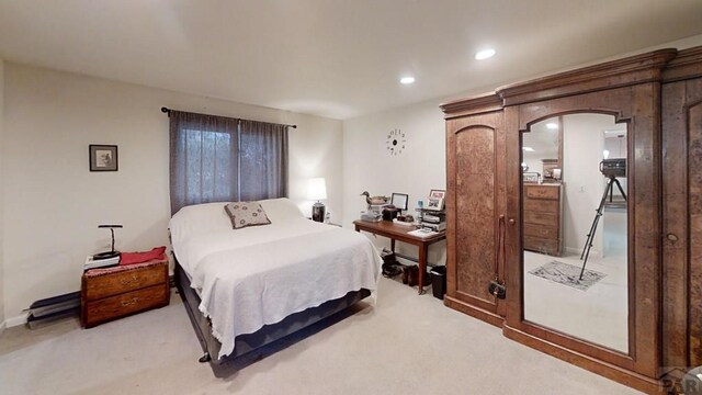 bedroom with arched walkways, recessed lighting, and light colored carpet