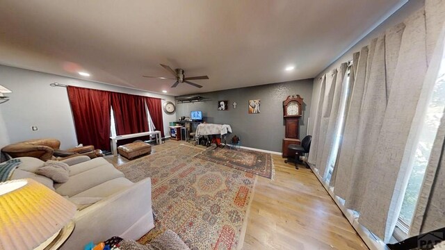 living room featuring a ceiling fan, recessed lighting, baseboards, and light wood finished floors