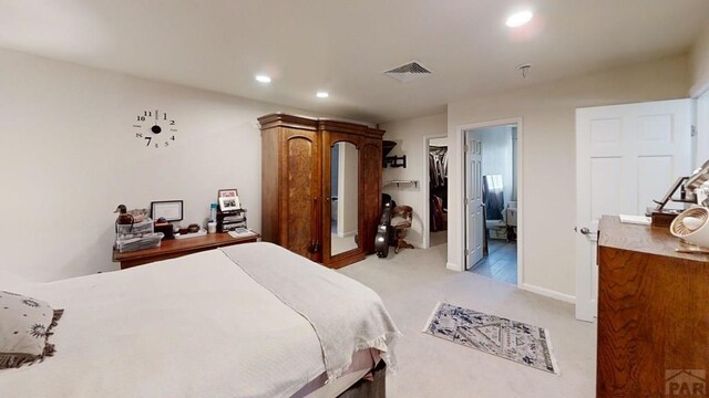 bedroom with recessed lighting, light carpet, visible vents, baseboards, and a spacious closet