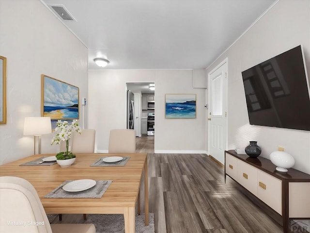 dining room with dark wood-style floors, visible vents, crown molding, and baseboards