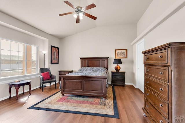 bedroom featuring ceiling fan, vaulted ceiling, baseboards, and wood finished floors