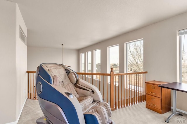 living area with light colored carpet, visible vents, and baseboards