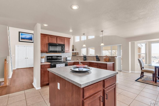 kitchen with a peninsula, black appliances, plenty of natural light, and light tile patterned floors